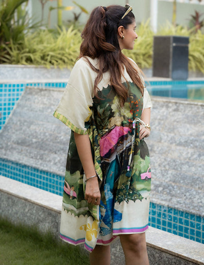 Woman in a floral dress standing by a poolside with plants in the background