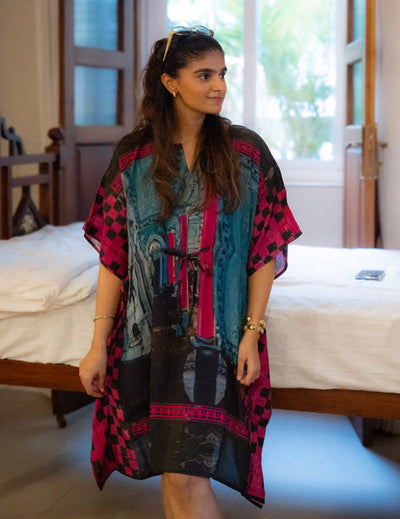 Woman wearing a colorful patterned dress in a bedroom setting